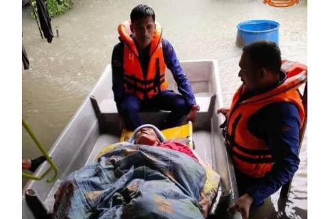 ANGKARA BANJIR: Anggota Angkatan Pertahanan Awam Malaysia (APM) memindahkan wanita warga emas mangsa banjir di Kampung Bakat, Machang, Kelantan, semalam. - Foto APM