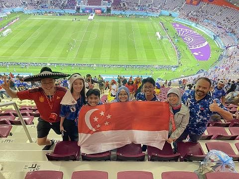 RASA GETARAN: Encik Samad (kanan) bersama keluarga dan warga Singapura lain menonton perlawanan Jepun menentang Sepanyol di Stadium Khalifa. - Foto-foto ihsan ABDUL SAMAD MAHAMOOD