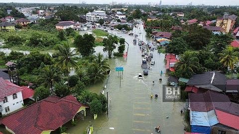 PANTAS BERBELANJA: Penduduk Pasir Mas bergegas membeli barang makanan asas berikutan banjir yang semakin buruk di Kelantan semalam. AKIBAT BANJIR BESAR: Laluan utama menghubungkan Tumpat dan Kota Bharu dinaiki air sedalam 0.5 meter menyebabkan jalan 