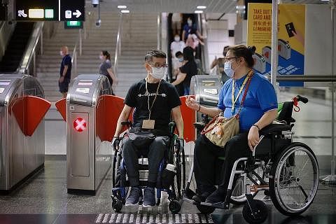 HULURKAN BANTUAN: Pembimbing stesen, Cik Helen Yan (kanan), membantu pengguna kerusi roda, Encik H.B. Tan, di stesen MRT Outram Park semalam. - Foto BH oleh JASON QUAH