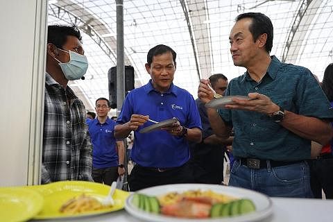 BERMESRA: Dr Koh Poh Koon (paling kanan) kelihatan mencuba masakan mi Burma bernama Ohn no Khao Swe, yang disediakan pekerja binaan Myo Min Oo (paling kiri), dalam sebuah acara Hari Migran Antarabangsa Ahad lalu. - Foto BH oleh FELINE LIM