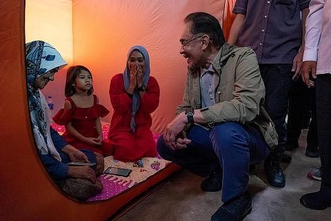 TINJAU KEADAAN: Datuk Seri Anwar Ibrahim melawat mangsa banjir di sebuah pusat pemindahan sementara di Pasir Mas, Kelantan kelmarin. - Foto FACEBOOK ANWAR IBRAHIM MANGSA BANJIR: Keputusan untuk memperuntukkan $15.21 juta kepada kedua-dua negeri itu d