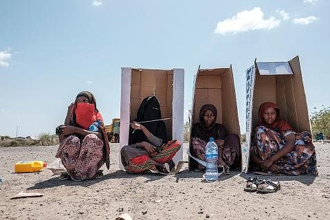 DI BAWAH TERIK MENTARI: Sekumpulan wanita dilihat duduk dengan beralaskan kadbod dengan jenama Pesuruhjaya Tinggi Bangsa-Bangsa Bersatu untuk Pelarian (UNHCR) sementara menunggu untuk berdaftar dengan pihak berkuasa di halaman Hotel Agda di kota Seme
