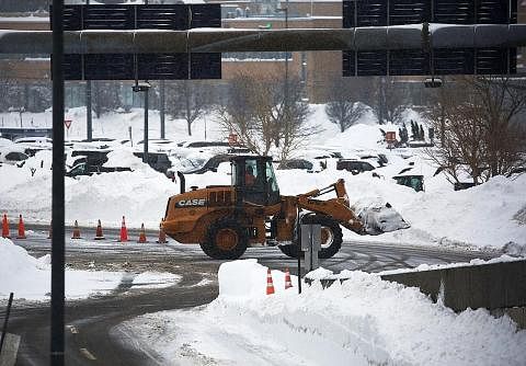 TIMBUNAN SALJI: Seorang petugas memandu jentolak bagi membersihkan jalan yang tidak boleh dilalui kenderaan di Lapangan Terbang Antarabangsa Niagara, Buffalo, New York, kelmarin akibat ribut salji terburuk yang melanda negeri itu. - Foto REUTERS