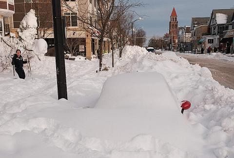 DITIMBUS SALJI: Sebuah kereta tertimbus dalam salji di Buffalo. Kakitangan kecemasan terpaksa memeriksa dari satu ke satu kereta mencari pemandu, sama ada hidup atau mati. - Foto AFP