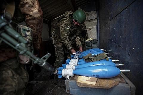 BERTAHAN DAN MENYERANG: Seorang askar Ukraine dilihat mempersiapkan bom mortar yang akan digunakan untuk menyerang kedudukan tentera Russia di pinggir Bakhmut, wilayah Donetsk, Ukraine, kelmarin. - Foto REUTERS