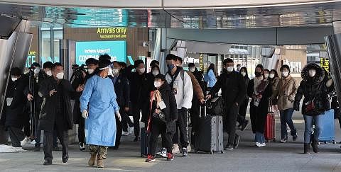 JALANI PEMERIKSAAN KESIHATAN WAJIB: Pengunjung dari China diiringi oleh pegawai kuarantin ke stesen ujian Covid-19 sebaik tiba di Lapangan Terbang Antarabangsa Incheon, Korea Selatan, kelmarin, apabila pemerintah Korea Selatan mula mewajibkan ujian P
