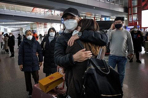 SYARAT KEMASUKAN DILONGGAR: Orang ramai berpelukan di pintu ketibaan pelancong dari luar negara di Lapangan Terbang Antarabangsa Ibu Kota Beijing selepas China menamatkan syarat kuarantin ke atas pelawat yang memasuki negara itu. - Foto REUTERS