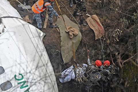 OPERASI MENCARI: Pasukan penyelamat memindahkan mayat korban nahas pesawat Yeti Airlines di Pokhara semalam. - Foto AFP