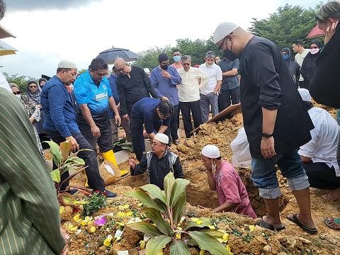 SELAMAT DISEMADIKAN: Jenazah Allahyarhamha Datin Paduka Julie Sudiro dikebumikan di tanah perkuburan di USJ22, Subang Jaya semalam. Berdiri di kanan adalah anak Allahyarhamha, Encik Rindra Soliano, manakala berdiri di tengah (dalam lot kubur) adalah 