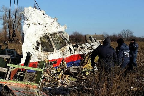 PENEMUAN BARU: Pekerja mengangkut serpihan pesawat Malaysia Airlines MH17 di lokasi ia jatuh berhampiran perkampungan Hrabove (Grabovo) di wilayah Donetsk, timur Ukraine, pada 20 November 2014. Penyiasat antarabangsa dijangka membentangkan penemuan b