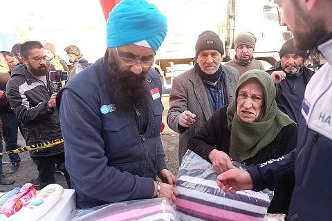HULUR BANTUAN: Pengerusi Lembaga Mercy Relief, Encik Satwant Singh (kiri) memberikan selimut kepada penduduk Elbistan yang kehilangan tempat tinggal, dengan cuaca sejuk memburukkan keadaan. - Foto BM oleh IZWANDI AZMAN