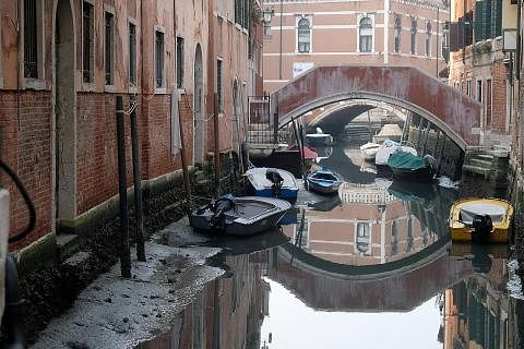 TIDAK DAPAT BERGERAK: Bot kelihatan 'tersangkut' di terusan semasa air surut yang teruk di bandar lagun Venice, Italy. - Foto REUTERS