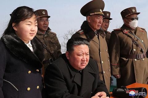MELIHAT UJIAN DARI DEKAT: Pemimpin Korea Utara, Encik Kim Jong Un, (dua dari kiri) hadir semasa ujian, sekali lagi bersama anak gadisnya (kiri), dengan latarbelakang peluru berpandu diluncurkan sebelum mengena sasaran di Cheolsan, wilayah utara Pyong