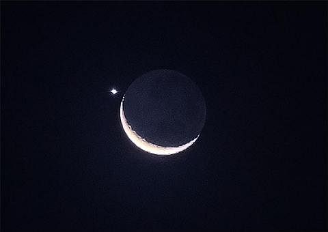 HIASI LANGIT MALAM: Pemandangan bulan sabit diiringi planet Zuhrah menghiasi langit malam pada Jumaat, 24 Mac. - Foto ST