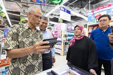 PILIHAN LUAS: Encik Masagos Zulkifli (paling kiri) meninjau antara 9,500 produk halal di pasar raya FairPrice, termasuk produk beku dan segar. Bersama beliau ialah (dari kiri) Pengurus penjualan dan pemasaran As-Sufi, Encik Abdul Rahman; Timbalan CEO