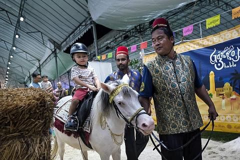 AKTIVITI KANAK-KANAK: Ibu bapa boleh mengajak anak-anak kecil melakukan kegiatan menarik di bazar, seperti menunggang kuda padi, bermain permainan arked dan memberi makan pada burung nuri.