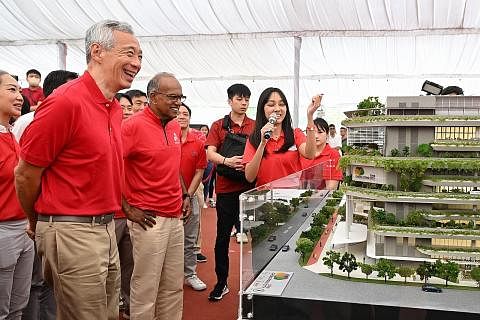 LIHAT MODEL PEMBANGUNAN: Perdana Menteri, Encik Lee Hsien Loong (paling kiri), dan Menteri Ehwal Dalam Negeri merangkap Undang-Undang, Encik K. Shanmugam, melihat model Chong Pang City di majlis pecah tanah yang berlangsung di Chong Pang pada Ahad. -