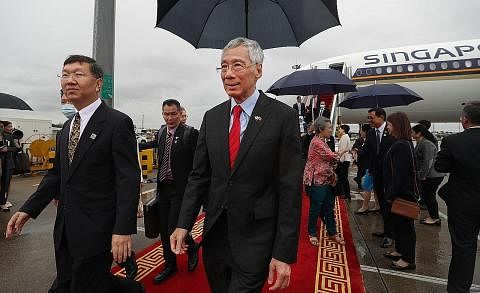 SELAMAT TIBA: Perdana Menteri, Encik Lee Hsien Loong (bertali leher merah), tiba di Guanzhou bagi memulakan lawatan rasmi ke China selama seminggu. - Foto MCI