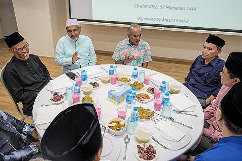 BERBUKA BERSAMA: Encik K. Shanmugam (tiga dari kiri), yang ditemani (dari kiri) Encik Masagos Zulkifli Masagos Mohamad; Pengerusi Masjid Khalid, Encik Allaudin Mohamed; dan Encik Saat A. Rahman, beramah bersama anggota kumpulan kariah semasa majlis b