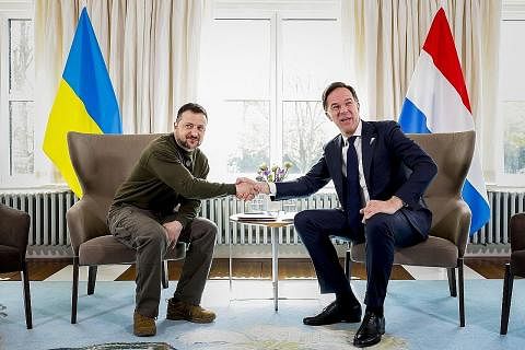 TANDA SOKONGAN: Perdana Menteri Belanda, Encik Mark Rutte (kanan) berjabat tangan dengan Presiden Ukraine, Encik Volodymyr Zelensky pada Khamis. Encik Zelensky akan bertemu dengan kepimpinan Mahkamah Jenayah Antarabangsa, yang telah mengeluarkan wara