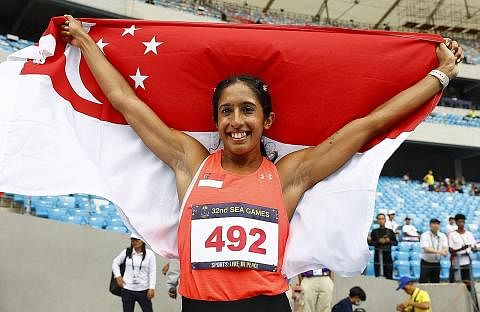 KEMENANGAN CEMERLANG: Srikandi perlumbaan pecut negara, Shanti Pereira, mengibarkan bendera negara semasa meraikan kejayaannya memenangi acara pecut wanita 200 meter dengan memecahkan rekod Sukan SEA acara itu. - Foto REUTERS