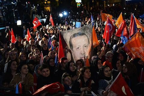 TUNJUK SOKONGAN: Penyokong Encik Recep Tayyip Erdogan membawa bendera dan sepanduk semasa Encik Erdogan berucap di satu acara di ibu pejabat Parti Pembangunan dan Kehakiman (AKP) di Ankara. - Foto EPA-EFE