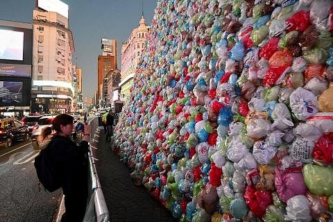 TINGKAT KESEDARAN: Seorang wanita di bandar Buenos Aires, Argentina, mengambil gambar hasil seni yang dihiasi beg-beg plastik yang bertujuan meningkatkan kesedaran awam sempena Hari Kitar Semula Sedunia pada 16 Mei 2023. - Foto AFP