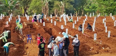 PERINGATAN: Kesedihan menyelubungi ahli keluarga mangsa Covid-19 yang dikebumikan di tanah perkuburan awam bagi korban virus itu di Pondok Ranggon di Jakarta Timur. - Foto fail