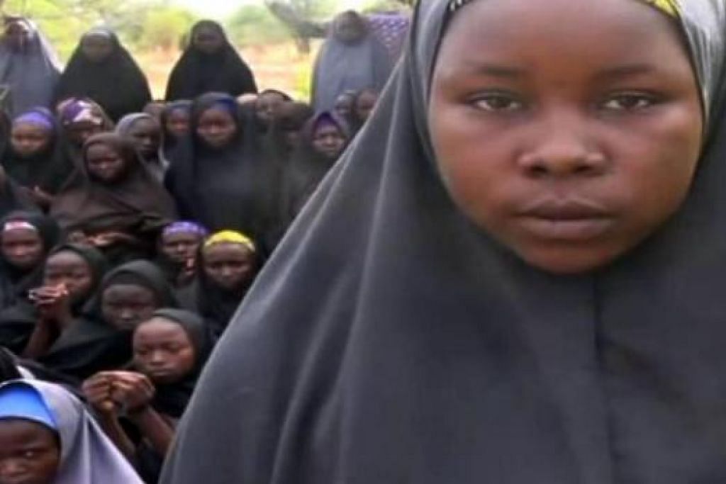 TAHANAN MILITAN: Gambar diambil daripada video kumpulan ekstremis Nigeria, Boko Haram, yang diperolehi AFP, menunjukkan anak-anak perempuan yang memakai hijab di lokasi yang tidak diketahui. Boko Haram menyiarkan video terbaru bagi mendedahkan anak-anak perempuan yang hilang yang didakwa mereka sudah memeluk agama Islam. Mereka akan ditahan sehingga pihak berkuasa membebaskan tahanan militan. Sejumlah 276 budak perempuan diculik di tenggara Chibok di Borno, semalam. Majoriti penduduk bandar itu adalah penganut Kristian. - Foto AFP