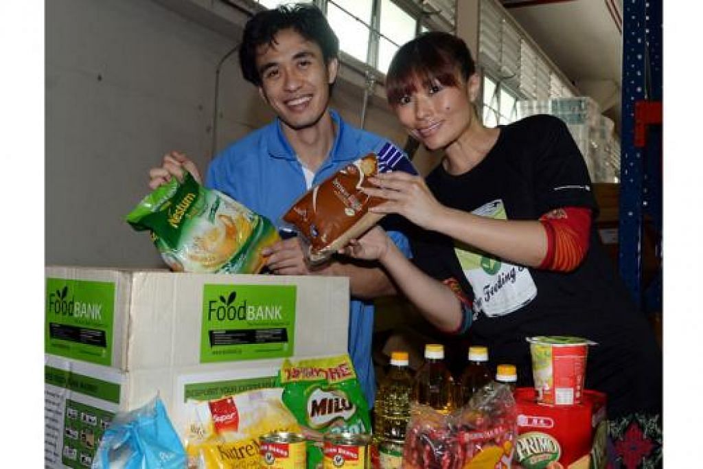 BANTU GOLONGAN SUSAH: Cik Nichol Ng bersama adiknya, Encik Nicholas Ng, memasukkan pelbagai jenis makanan ke dalam kotak Food Bank untuk diagihkan kepada badan-badan kebajikan. - Foto TAUFIK A. KADER