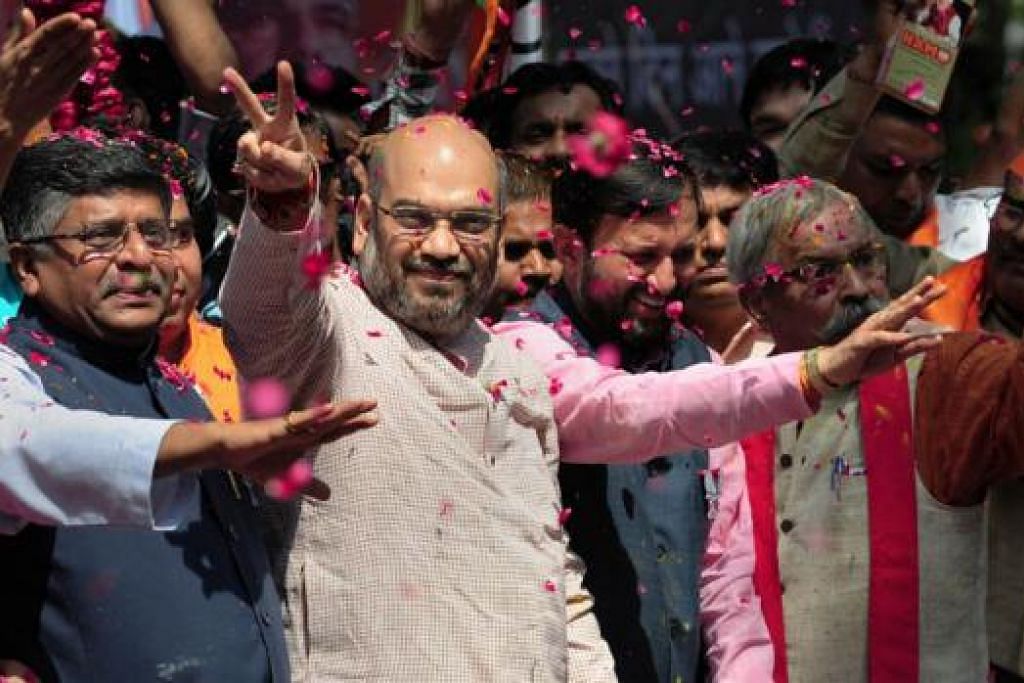 RAIKAN KEMENANGAN: Pemimpin kanan Parti Bharatiya Janata (BJP), Encik Amir Shah (tengah) dan Encik Ravi Shankar Prasad (kiri), melambai-lambai kepada penyokong sedang mereka meraikan kemenangan parti itu semalam.