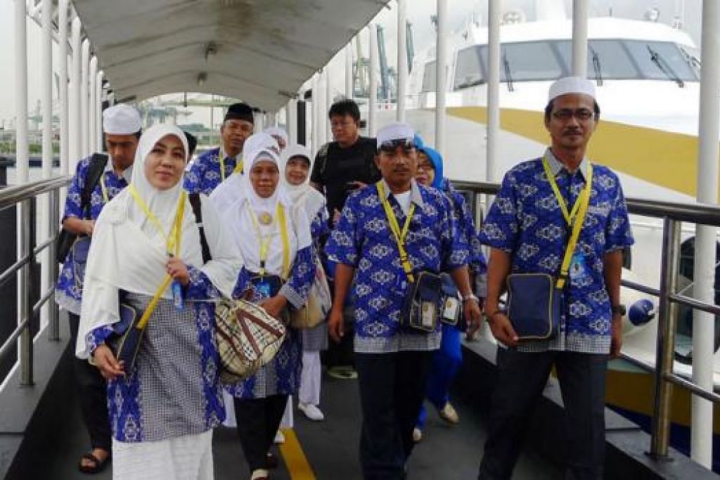 DARI BATAM KE SINGAPURA: Jemaah Indonesia berjalan di jeti Harbourfront selepas turun dari feri yang membawa mereka dari Batam.