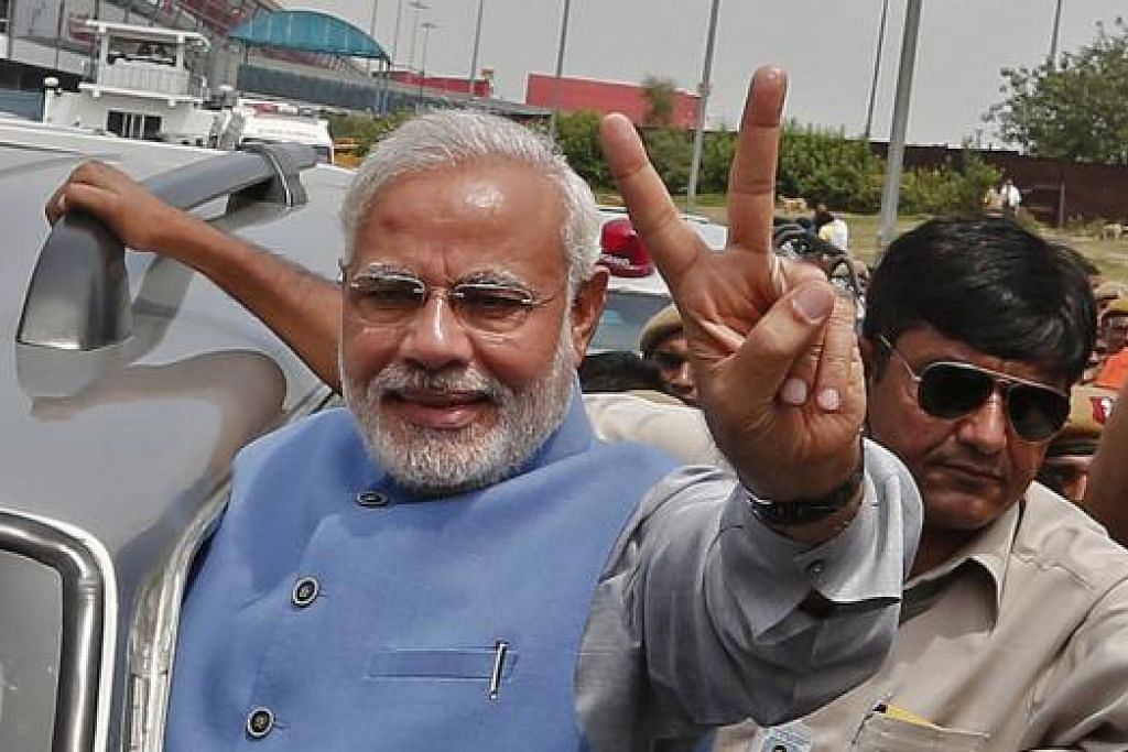 BAKAL KETUA PEMERINTAH: Encik Narendra Modi daripada Parti Bharatiya Janata (BJP) memberi isyarat 'keamanan' kepada penyokongnya semasa ketibaan beliau di lapangan terbang di New Delhi semalam. - Foto REUTERS