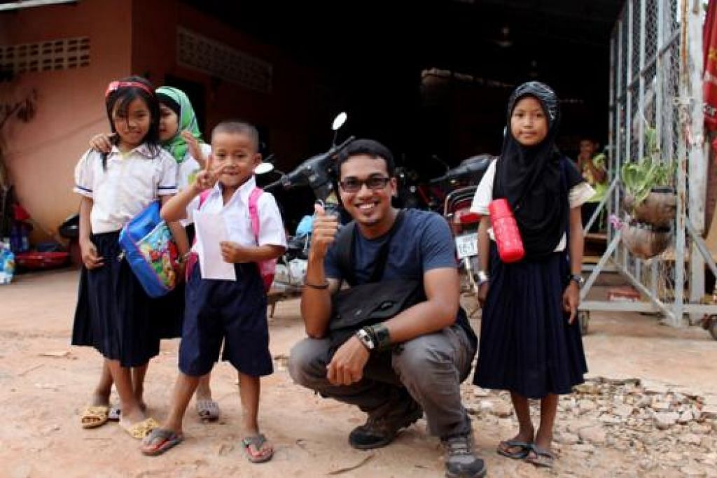 DENGAN SI CILIK: Encik Muhammad Firdaus Marzuki berinteraksi dengan kanak-kanak sekolah dari Kemboja.