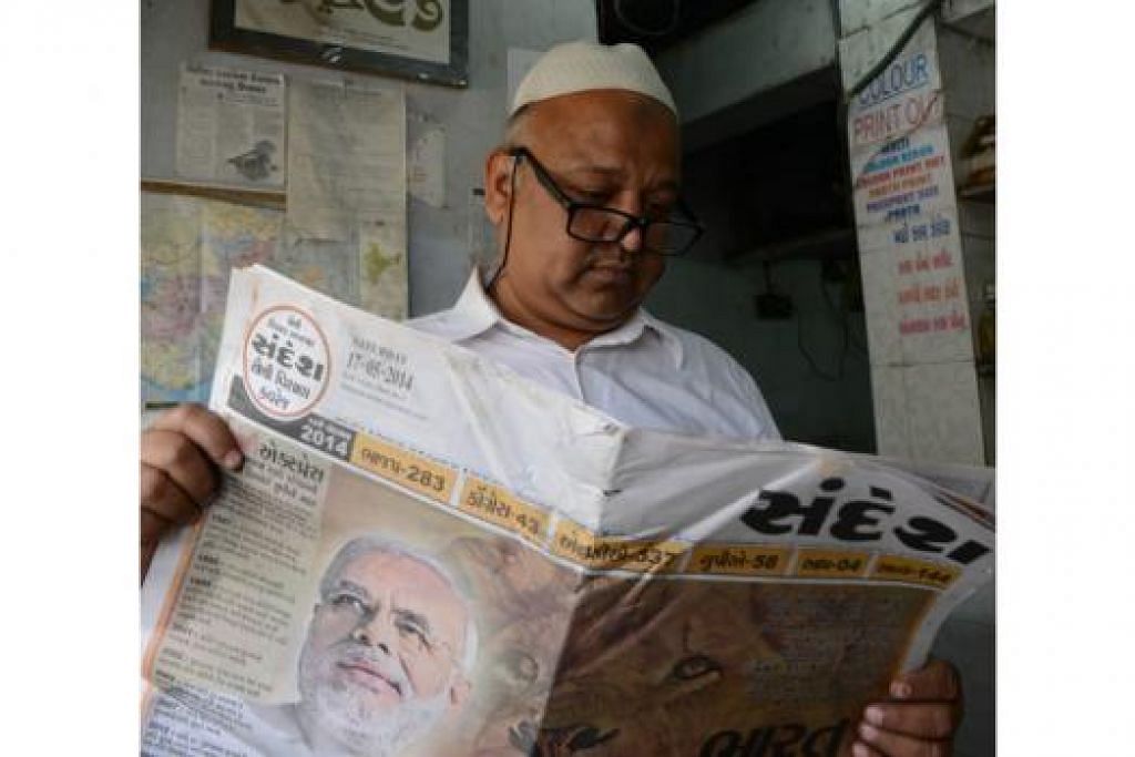 BERITA HANGAT: Seorang penduduk membaca akhbar Sandesh, salah satu akhbar utama di wilayah Gujarat, mengenai pemimpin BJP, Encik Narendra Modi. - Foto-foto AFP