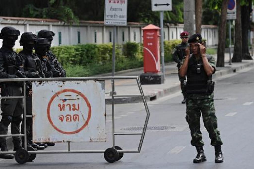 TEMPAT LAPOR DIRI: Anggota tentera Thailand semalam berjaga di luar auditorium tentera, tempat tokoh-tokoh politik termasuk mantan perdana menteri Cik Yingluck Shinawatra telah diminta melapor diri. - Foto AFP