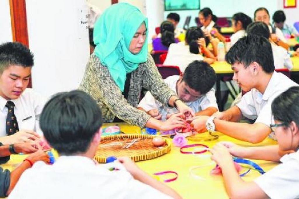 KENALI BUDAYA MELAYU: Cikgu Shahirah Sianturi Shahrir menunjukkan kepada pelajar cara membuat bunga telur bagi majlis perkahwinan Melayu. - Foto-foto KHALID BABA