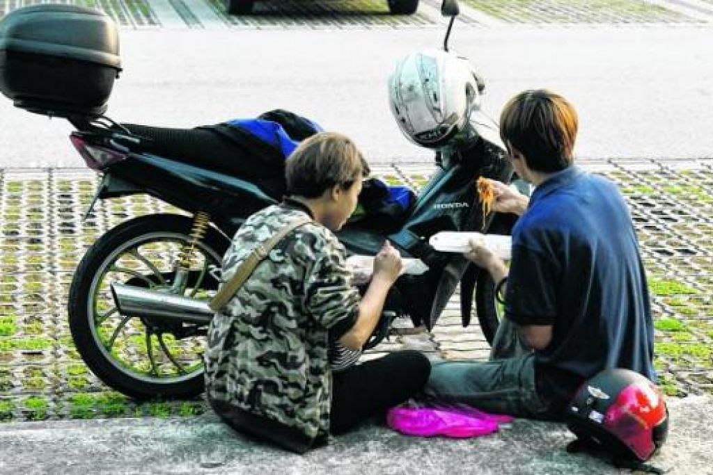 BERHENTI SEJENAK: Dua pekerja dari Malaysia ini bersarapan di Woodlands Waterfront Park selepas lebih sejam berasak di Koswe memasuki Singapura. - Foto JOHARI RAHMAT 
