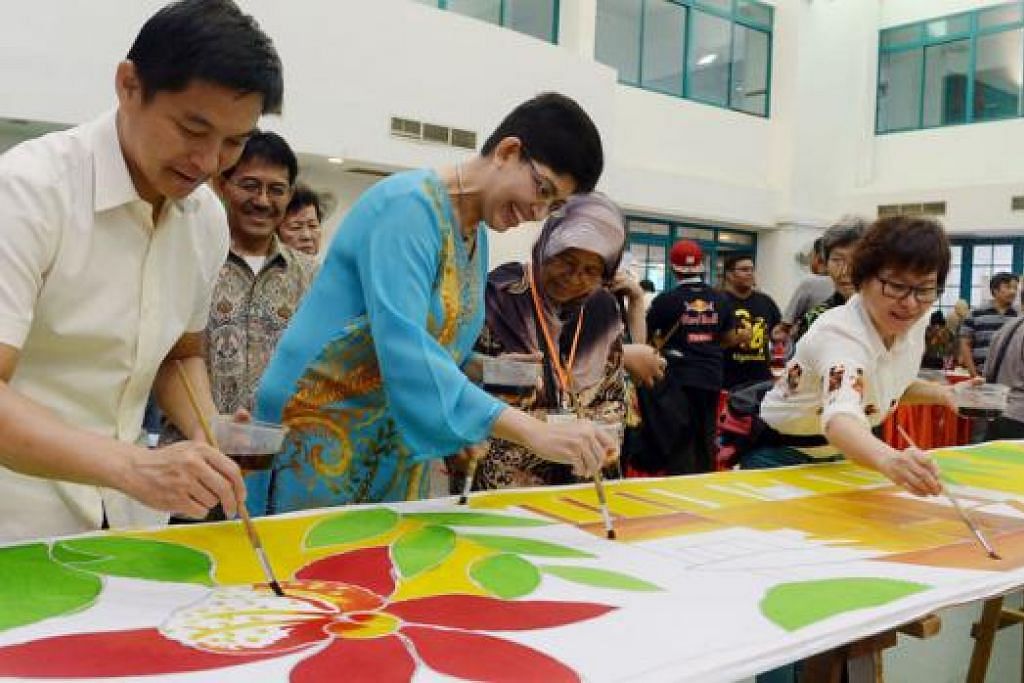 RAI BUDAYA: Encik Tan (kiri) dan Dr Fatimah (baju biru) menyertai beberapa penduduk melukis batik dalam pesta budaya Melayu yang dianjurkan semalam menjelang projek lampu Raya Geylang Serai bukan depan. - Foto TAUFIK A. KADER