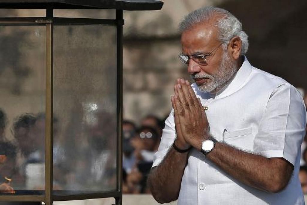 PEMIMPIN BARU INDIA: Encik Modi memberi penghormatan di tugu peringatan Mahatma Gandhi di Rajghat sebelum upacara mengangkat sumpah sebagai Perdana Menteri di New Delhi. - Foto REUTERS 