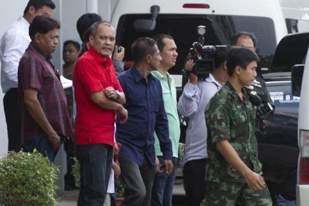 TELAH DIBEBASKAN: Pemimpin bantahan Baju Merah, Encik Natthawut Saikua (tengah, baju merah), berdiri bersama keluarganya selepas dibebaskan daripada kemudahan tentera di Bangkok semalam. Turut dibebaskan ialah mantan Perdana Menteri Thailand, Cik Yingluck. – AFP