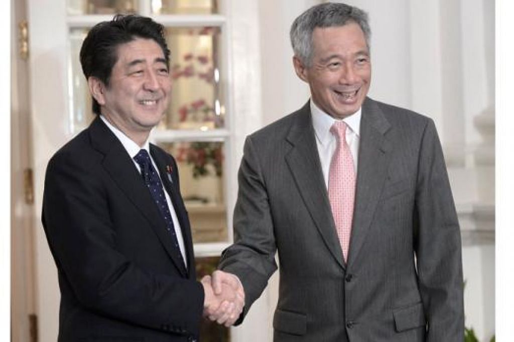 JABATAN MESRA: Encik Shinzo Abe (kiri) berjabat tangan dengan Encik Lee Hsien Loong, selepas mereka bertemu di Istana semalam untuk berbincang tentang peranan Jepun yang lebih aktif di rantau ini. - Foto AFP