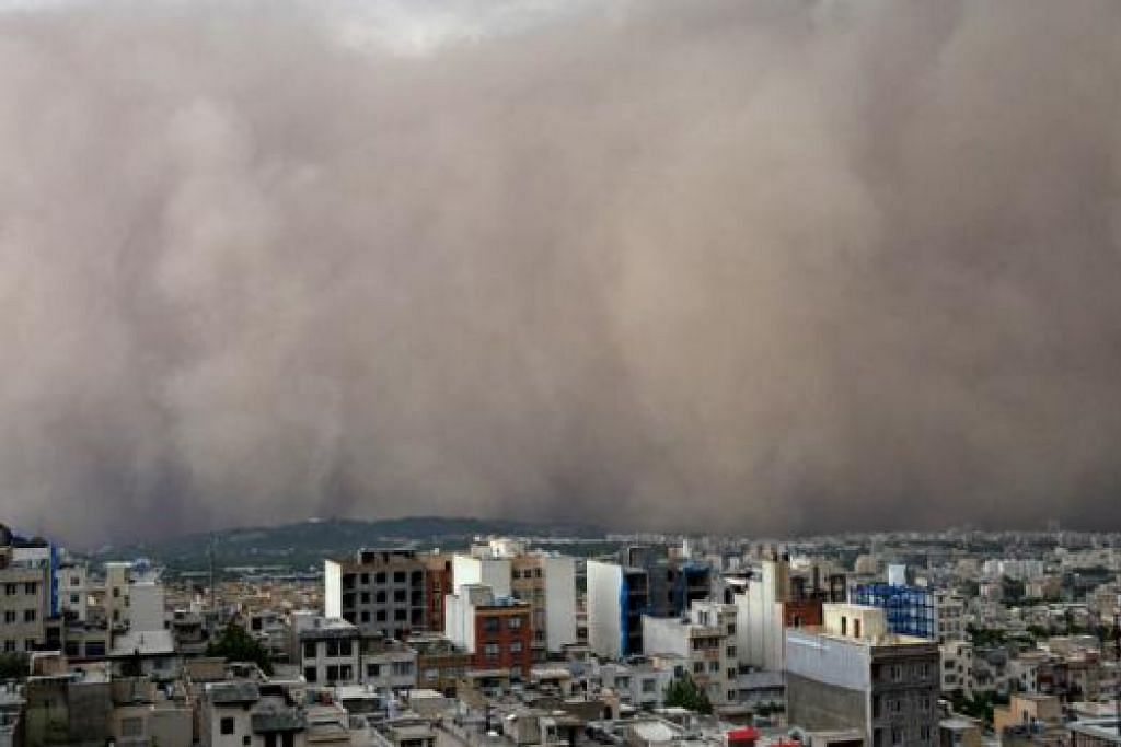 DEBU TEBAL: Pemandangan ribut pasir luar biasa ketika ia mula membadai bandar Minicity dan Menara Milad di Teheran, Iran. Bandar itu kemudiannya menjadi gelap, bekalan tenaga terputus dan banyak bangunan mengalami kerosakan. - Foto AFP