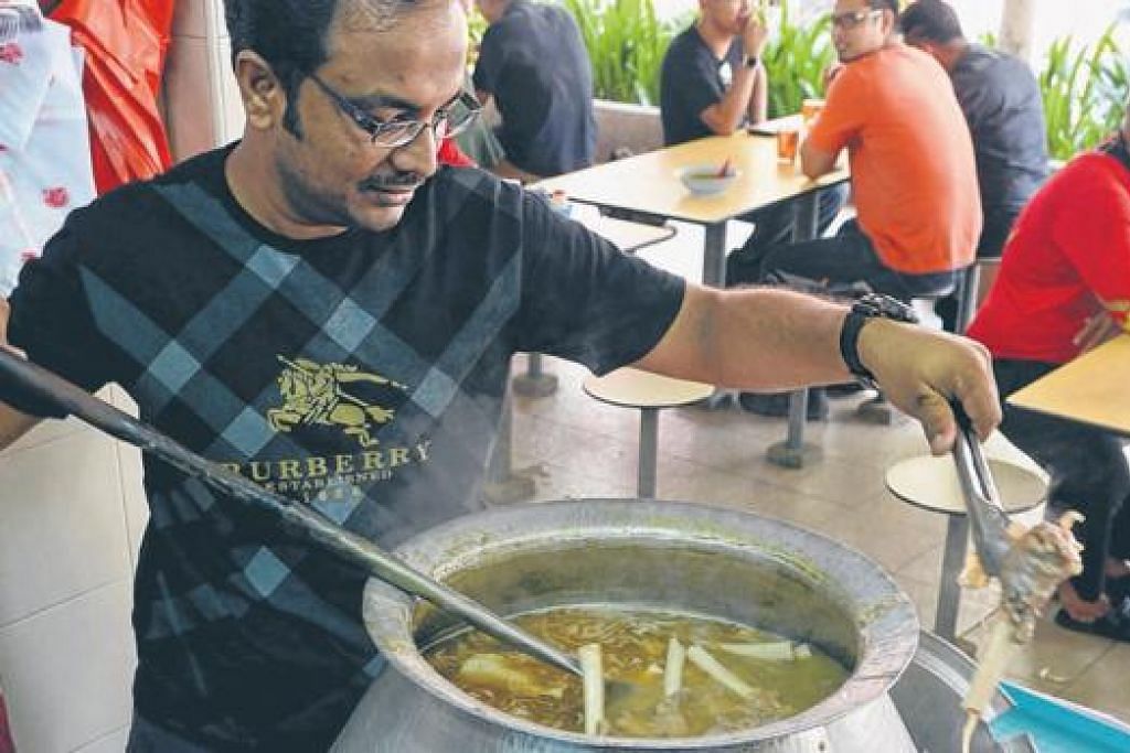 HIDANGAN IDAMAN: Encik Haja Maideen mengacau sup kambing di gerai Haji Abdul Rajak yang dimasak selama tiga jam menggunakan lebih 20 jenis rempah-ratus dari rantauan, seperti India dan Indonesia. - Foto-foto TUKIMAN WARJI