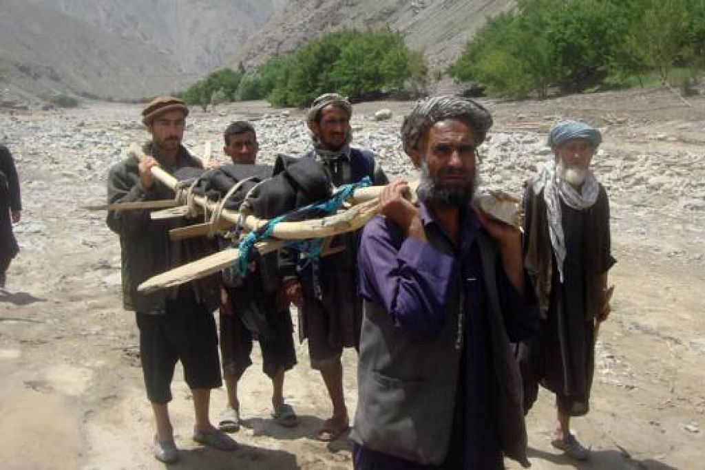 KORBAN BENCANA BANJIR: Beberapa penduduk membawa mayat penduduk selepas banjir kilat melanda kawasan di utara Afghanistan yang membunuh lebih 70 penduduk dan menenggelamkan ratusan rumah. - Foto AFP