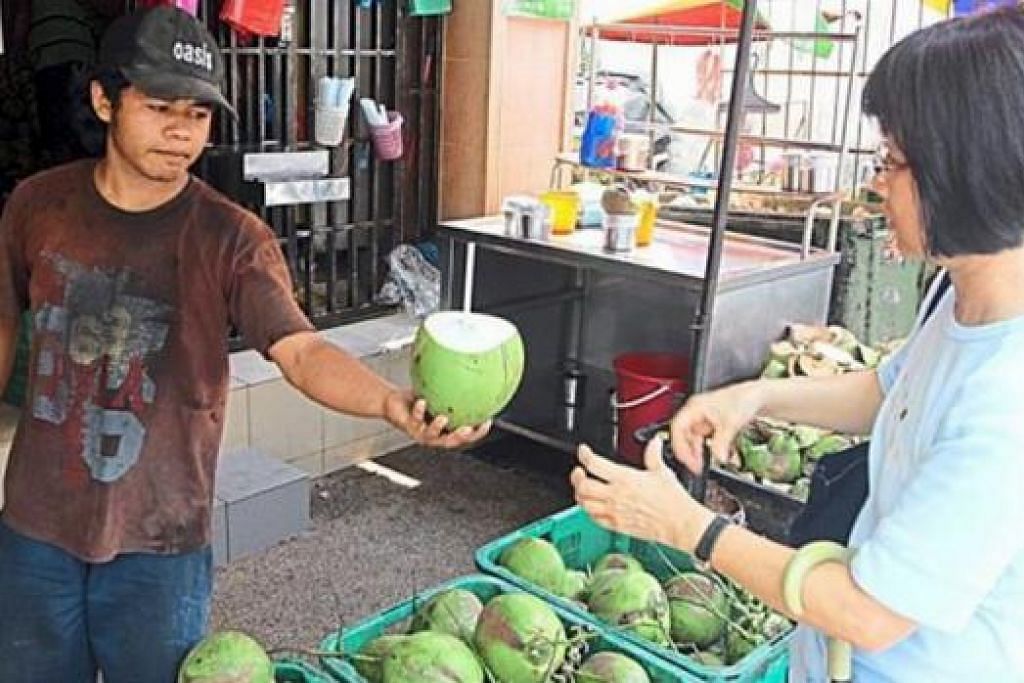 PERNIAGAAN MELONJAK: Seorang penjual kelapa muda melayan pelanggan di sebuah kedai di Abu Siti Lane, Georgetown. Permintaan bagi kelapa muda kini meningkat berikutan cuaca panas sejak beberapa hari lalu. - Foto THE STAR