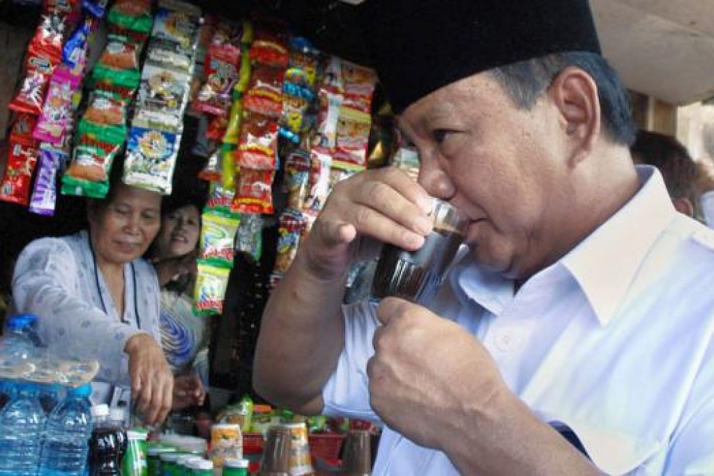GIAT BERKEMPEN: Encik Prabowo Subianto sempat minum kopi di sebuah warung sebelum berucap semalam. - Foto-foto AFP