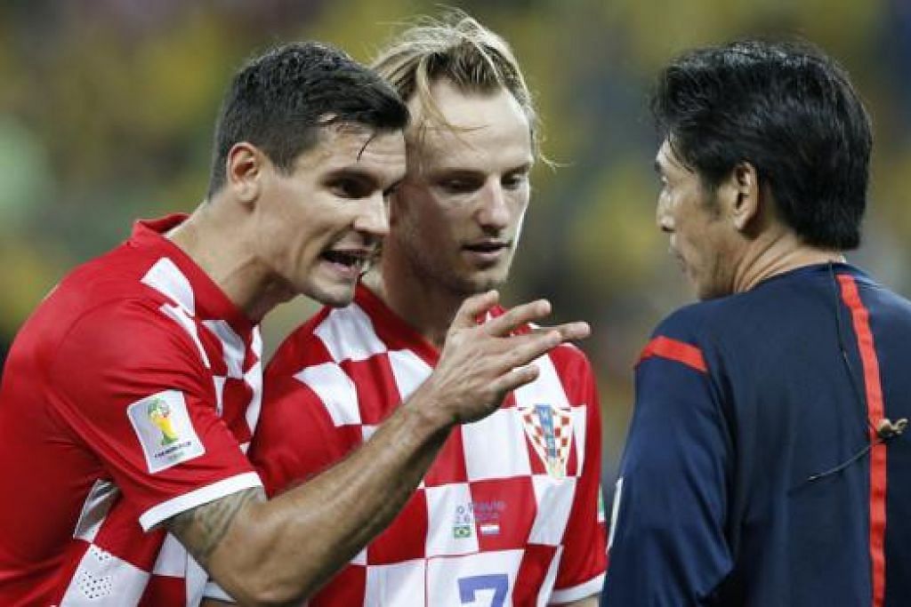 KONTROVERSI: Pemain Croatia Dejan Lovren (kiri) dan Ivan Rakitic kurang setuju dengan keputusan pengadil Jepun Yuichi Nishimura (kanan) memberikan penalti kepada Brazil dalam perlawanan pembukaan. – Foto AFP