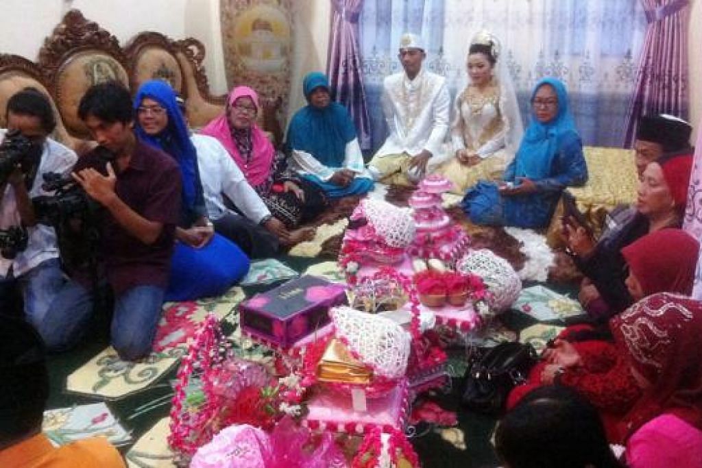 ADAT ISTIADAT MELAYU MASIH TEGUH: Pasangan pengantin, Encik Nurul Hidayat dan Cik Amanda Pratiwi, bergambar bersama barang hadiah yang dibawa rombongan pengantin lelalki. 